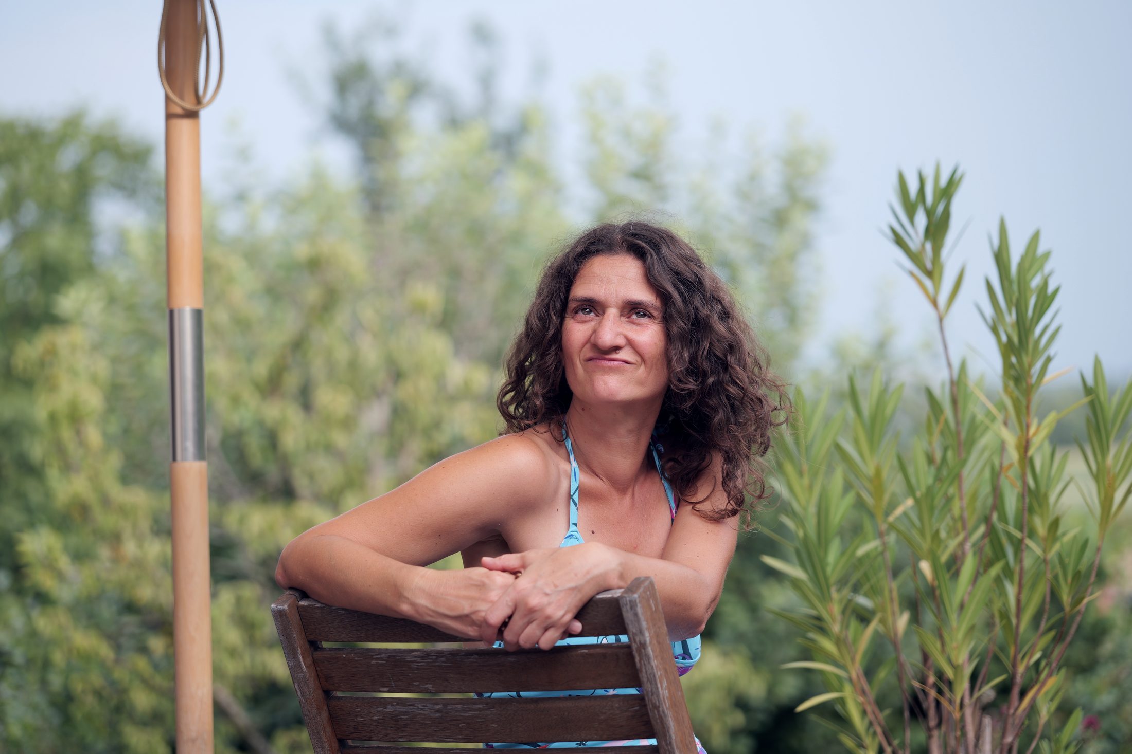 Ulrike Zacherl im Garten, an einen Stuhl gelehnt